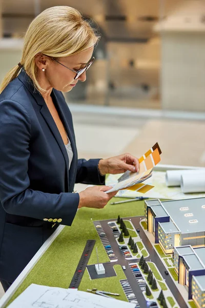 Visão lateral sobre empresária investidor escolhendo a cor do futuro edifício no modelo 3d — Fotografia de Stock