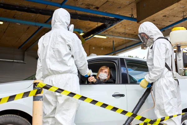 Travailleurs médicaux mesurant la température de la femme à travers la fenêtre de voiture — Photo