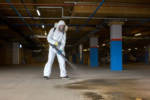 Professional worker in hazmat suit is making disinfection outdoors — Stock Photo, Image