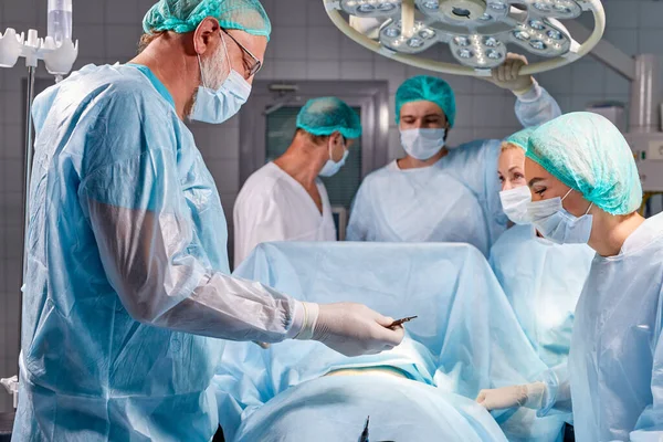 Equipe de cirurgiões profissionais está lutando pela vida do paciente doente — Fotografia de Stock