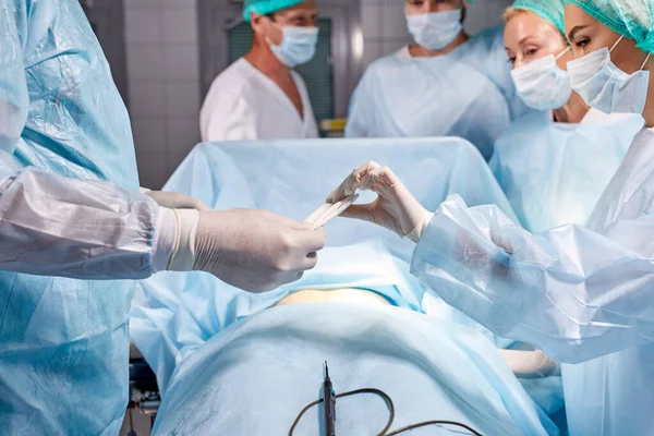 Profesyonel, zeki, ciddi, tıbbi üniforma giyen cerrahlardan oluşan bir ekip zor bir ameliyat geçirdi. — Stok fotoğraf