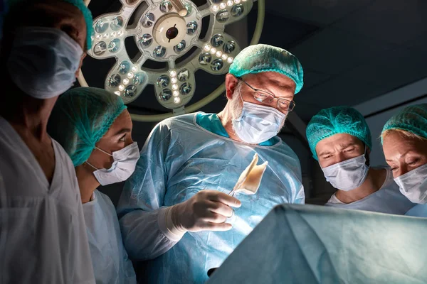 Profesyonel cerrahlar, hasta bir hastanın hayatı için savaşıyor. — Stok fotoğraf