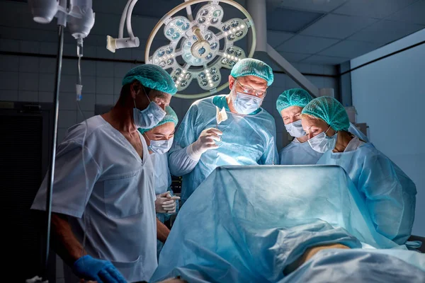 Pewni siebie kaukascy lekarze i asystenci biorą poród — Zdjęcie stockowe