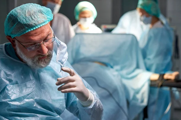 Homem cirurgião profissional cansado tirando a máscara após operação mal sucedida — Fotografia de Stock