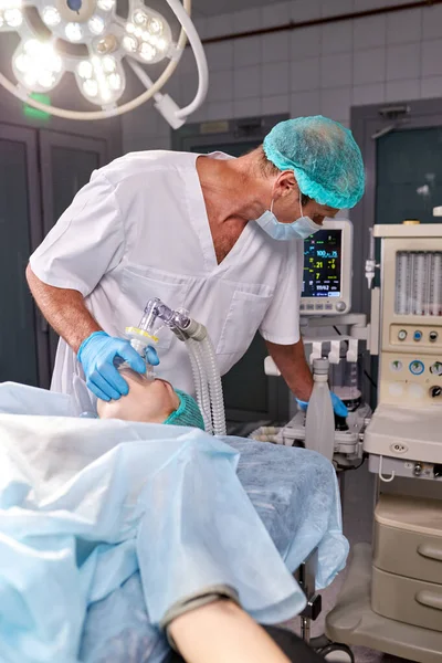 Jeune chirurgien masculin concentré sur le travail avec le patient — Photo
