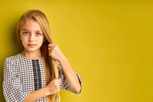 Portret van aantrekkelijke kid meisje aanraken van haar lange rechte haar — Stockfoto