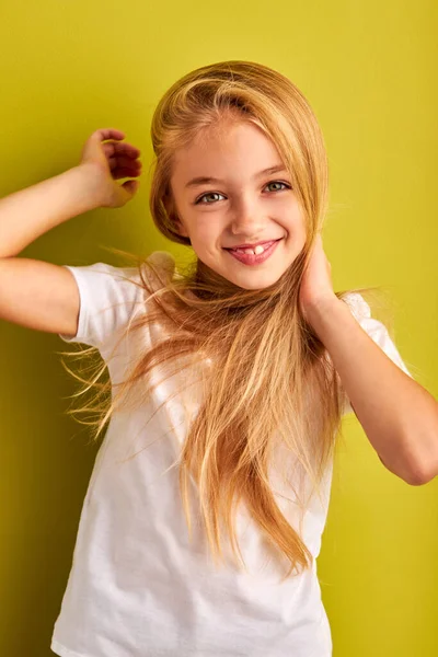 Adorable mignon caucasien enfant fille avec les cheveux longs posant à la caméra, souriant isolé — Photo
