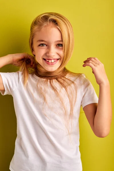 Portrait of positive child girl with long blond hair isolated on green background — Foto de Stock