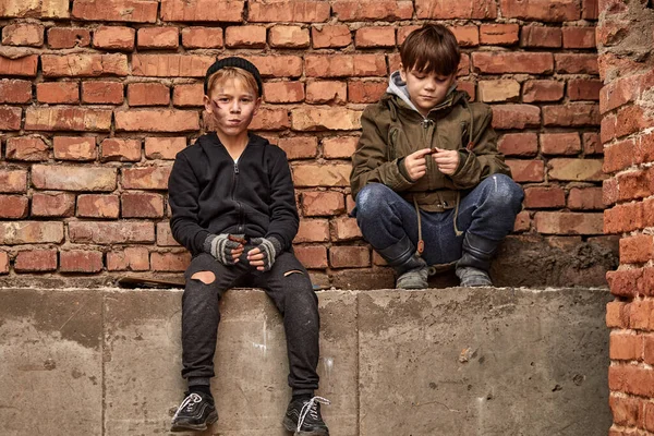 Twee vriendelijke straat jongens delen stuk brood, eten samen — Stockfoto