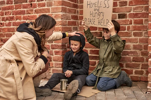 ホームレスの子供たちを助ける通りの見知らぬ女性 — ストック写真