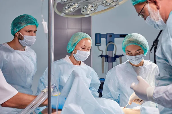 แพทย์ผู้ใหญ่มืออาชีพแสดงตัวอย่างของการผ่าตัดเพื่อฝึกงานหรือนักเรียน — ภาพถ่ายสต็อก