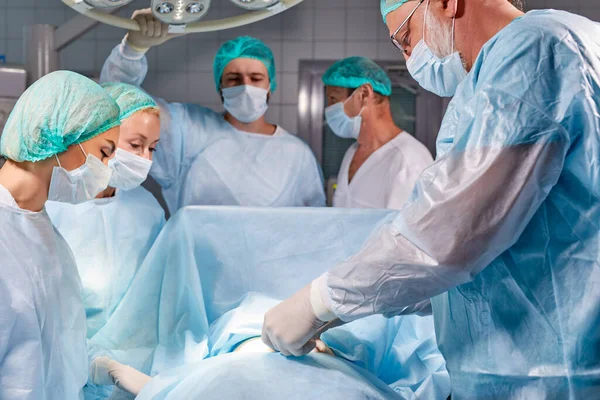 Equipe de profissionais cirurgiões sérios inteligentes vestindo uniforme médico teve operação difícil — Fotografia de Stock