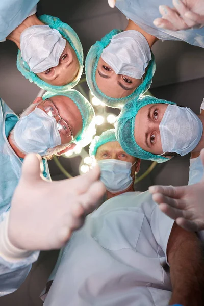 view from below of professional experienced surgeons with medical tools during operation