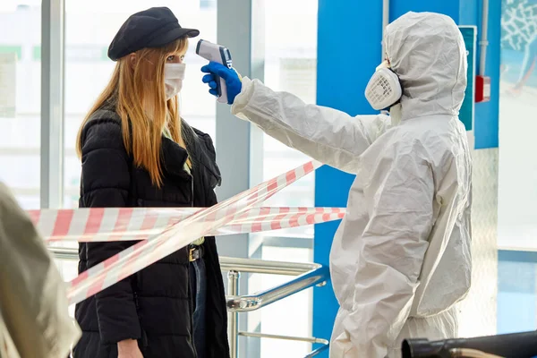 Portrait of specialist in medical suit examining the fever of guests —  Fotos de Stock