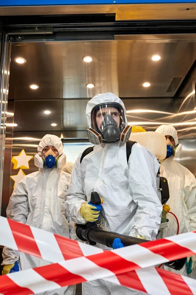 Equipo de desinfectantes profesionales que entran en el edificio —  Fotos de Stock