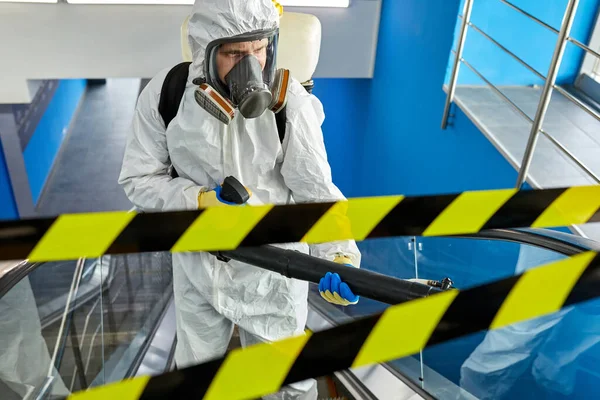 Fertőtlenítőszer védőruhában és maszkban épületen belüli mosás — Stock Fotó