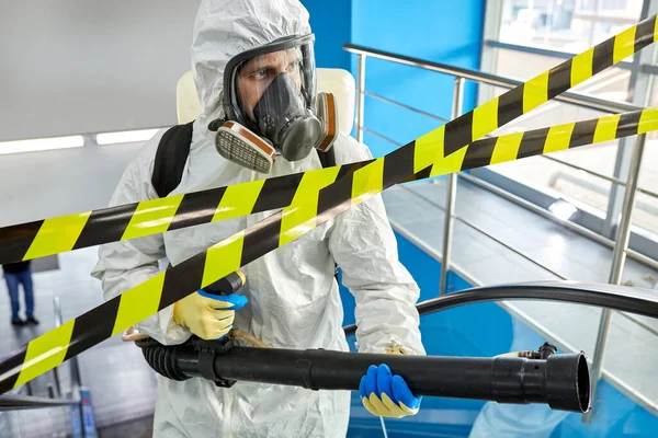 Trabajador médico desinfectando las superficies interiores dentro del edificio — Foto de Stock