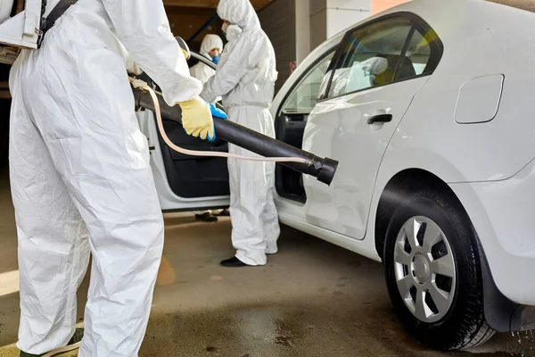 Equipe de trabalhadores de saneamento em terno hazmat limpeza do carro — Fotografia de Stock