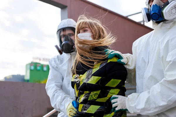 Young infected woman with a coronavirus is taken out of the quarantine zone —  Fotos de Stock