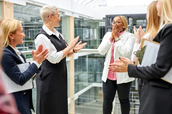 Friendly team of women celebrate their african colleagues — Stock Photo, Image