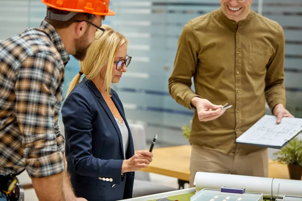 Vrouwelijke ontwerper architect geeft aanwijzingen aan ingenieurs — Stockfoto