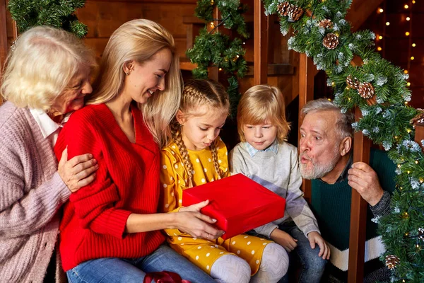 Дети получают рождественские подарки от матери и бабушки — стоковое фото