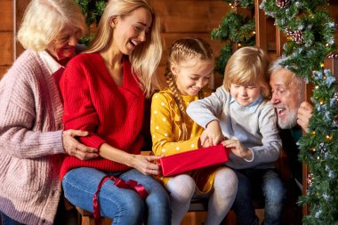 Çocuklar akrabalarının hediyelerini açarlar.