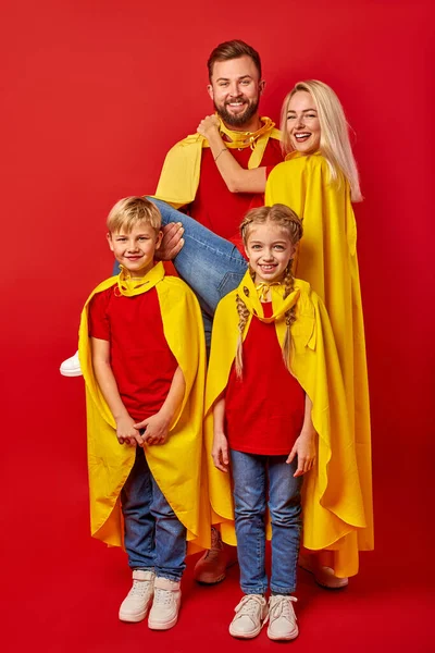 Happy parents playing superheroes with children — Stock Photo, Image