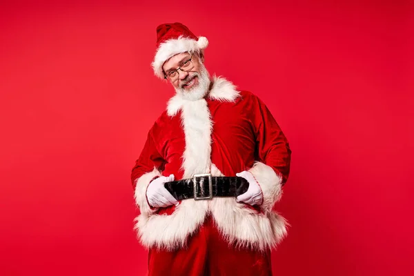 Санта-Клаус с неприятной улыбкой позируют изолированы на красном фоне — стоковое фото