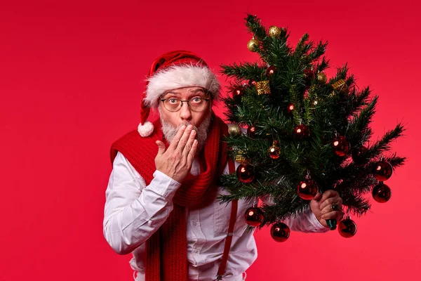 Удивленный Санта-Клаус с украденной елкой в руках — стоковое фото