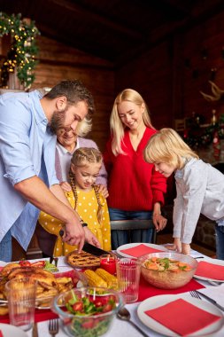Geniş aile portresi, birlikte noel pastası oyma.