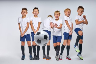Futbol topu gollerini savunan çocuklara doğru uçuyor.