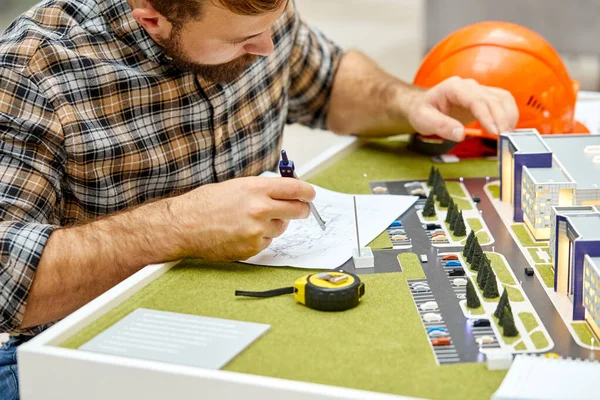 Arquiteto ou engenheiro trabalhando com projeto de construção na mesa — Fotografia de Stock