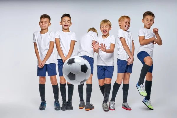 Bola de futebol voa para os meninos defendendo seu objetivo — Fotografia de Stock