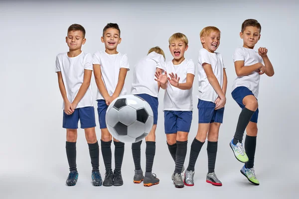 Futbol topu gollerini savunan çocuklara doğru uçuyor.