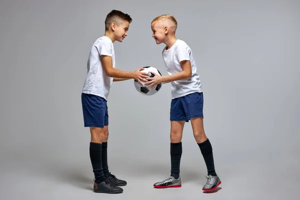 Dois jogadores de futebol caucasianos estão em frente um do outro compartilhando uma bola — Fotografia de Stock