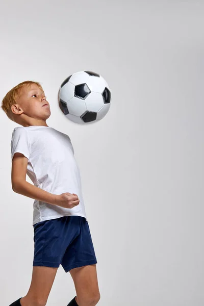 Capaz de treinamento esportivo menino sozinho com bola de futebol — Fotografia de Stock