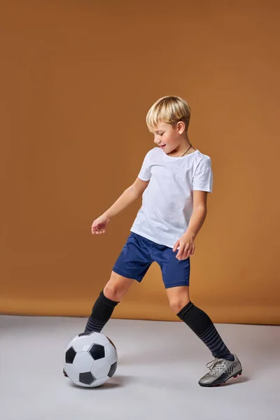 Jovem jogador de futebol menino jogando com bola, chutando — Fotografia de Stock