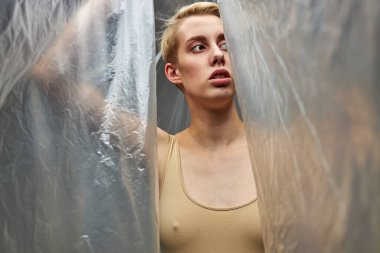 Kadın plastik çöp torbasının çıkışlarını arıyor.