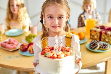 Mutlu utangaç kız ellerinde doğum günü pastasıyla