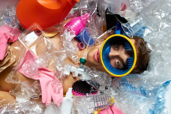 Porträtt av killen som ligger runt plast skräp skräp — Stockfoto