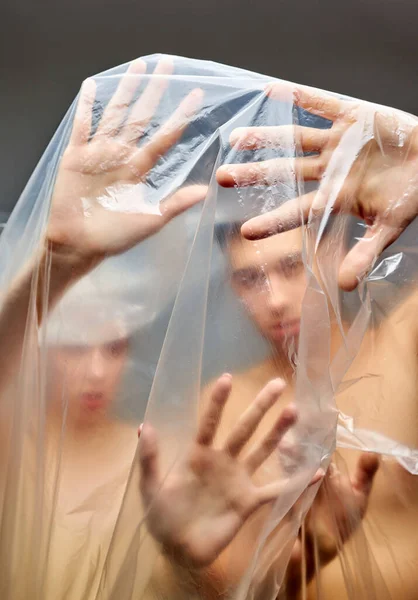Portret beznadziejnej pary zawiniętej w jednorazowe plastikowe torby — Zdjęcie stockowe