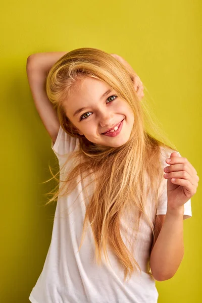 Enfant fille gaie avec de longs cheveux blonds isolés sur fond vert — Photo
