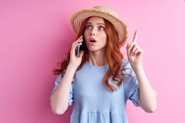 Harika bir fikir. kızıl saçlı kadın telefon kulübesinde konuşurken düşünüyor.