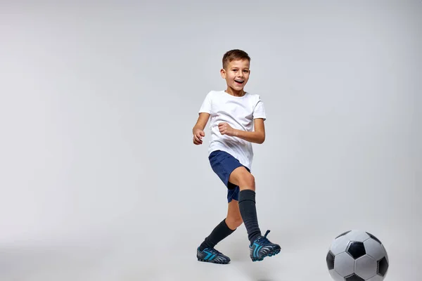 Jovem jogador de futebol menino jogando com bola, chutando — Fotografia de Stock