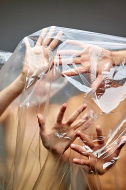 İnsanların ellerinin yakın plan fotoğrafı plastik atıkların hapsedilmesinden kurtulmak istiyor.