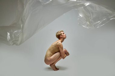 Diz çökmüş, geri dönüşümsüz plastik poşet giymiş kadın üzerinde yan görüş