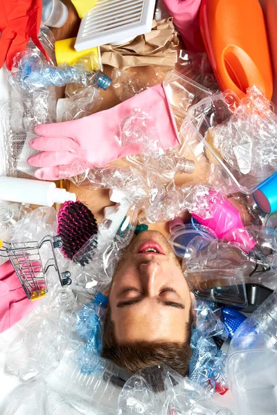 Naken man ligger anong tomma plastflaskor och skräp — Stockfoto