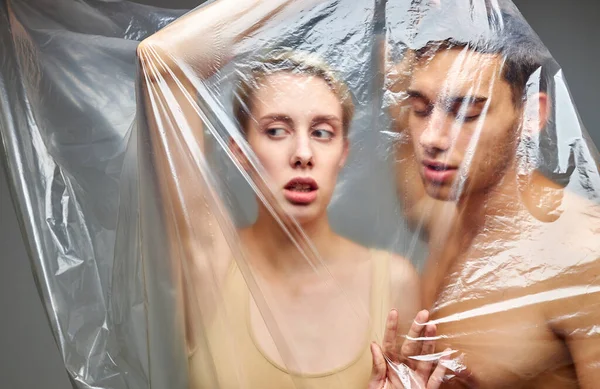 Caucasian half-naked man and woman in polyethylene — Stock Photo, Image