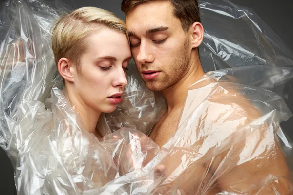 Caucasian half-naked man and woman in polyethylene — Stock Photo, Image